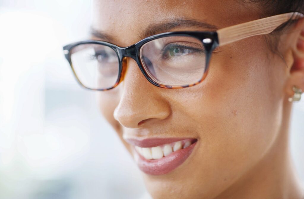 Close-up of person wearing rectangular eyeglasses with wood-textured arms, showcasing stylish and modern eyewear fit.